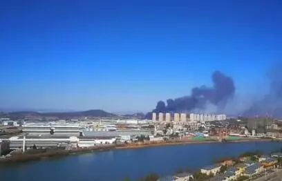 倉庫里往外冒著滾滾黑煙，把周圍的天空染上烏黑色。